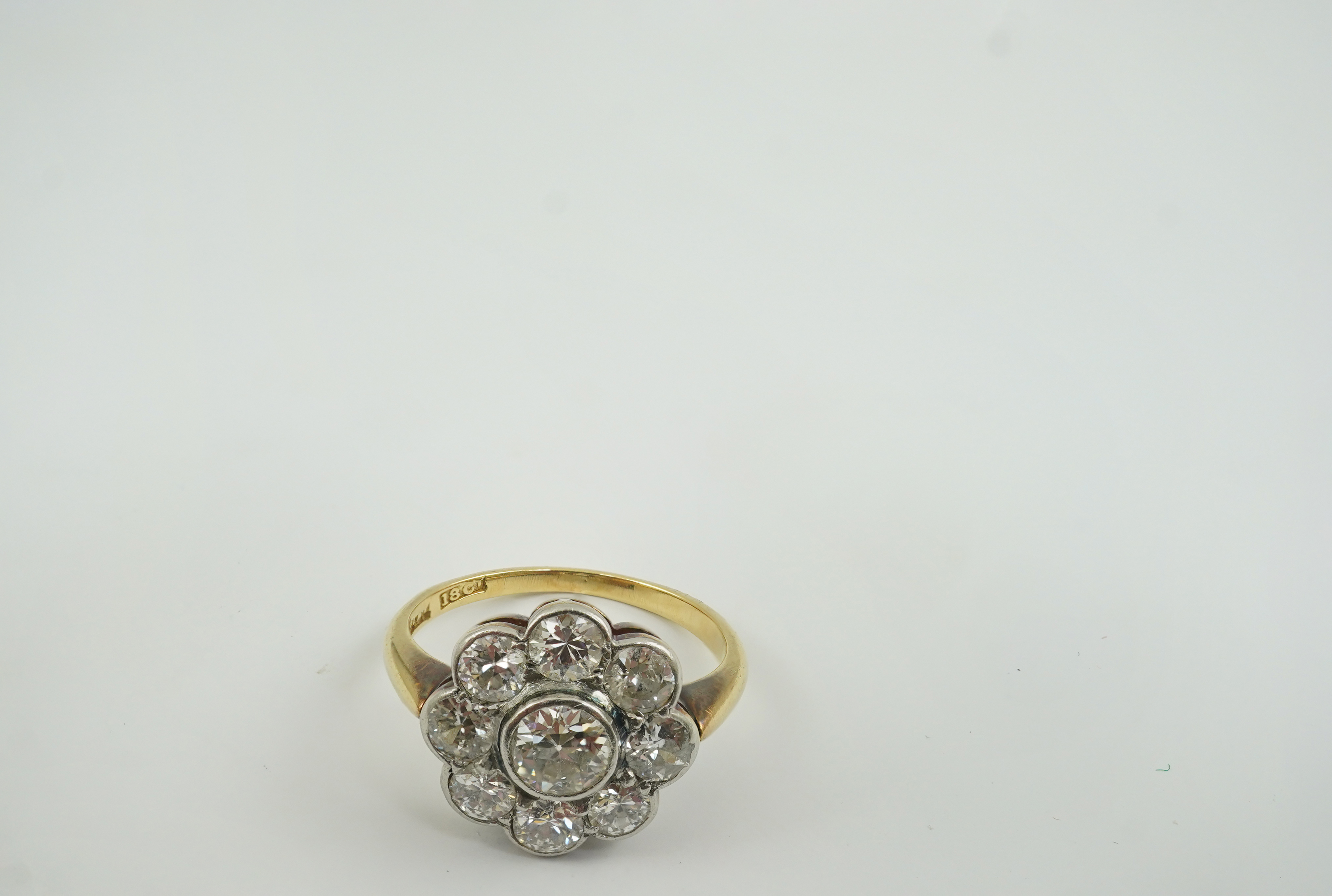 A mid 20th century 18ct gold and nine stone diamond set flower head cluster ring